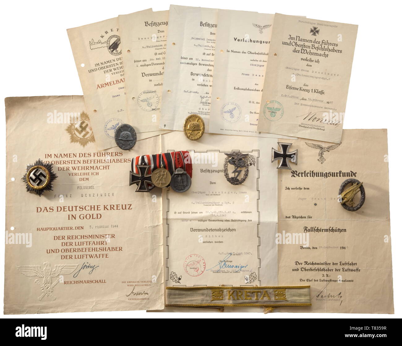 The estate of Paratrooper Franz Denzinger German Cross in Gold, 'heavy' issue of maker Deschler, Munich. The attachment pin (old repair between hinge and pin) with '1' punch. Weight 70.5 g. Included is the award document dated '5. FEBRUAR 1944' (holed, creased, the reverse laminated). Also, a Paratrooper's Badge with the award document dated '26. September 1940', a Luftwaffe Ground Combat Badge, silver-plated fine zinc with riveted eagle and the award document dated '26.Mai 1943' with original signature of Student, and a 'Kreta' cuff title, examplar detached from a uniform,, Editorial-Use-Only Stock Photo