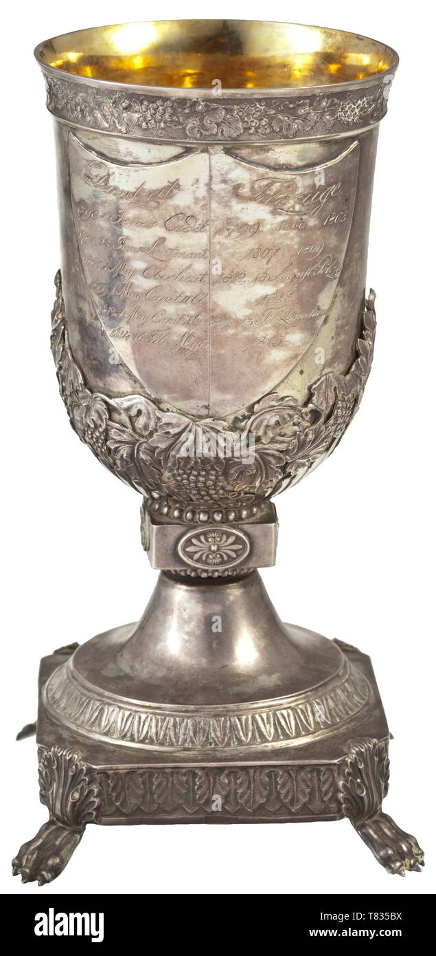 A parting goblet for Major Franz von Harren Silver goblet (19 cm in height) on a quadratic base with a décor of ornamental leaves and supported by four lion´s paws. The goblet vessel, retained by vines and leaves and separated from the base by a beaded section and an intermediate square base, carries on its obverse and reverse a text shi 19th century, Additional-Rights-Clearance-Info-Not-Available Stock Photo