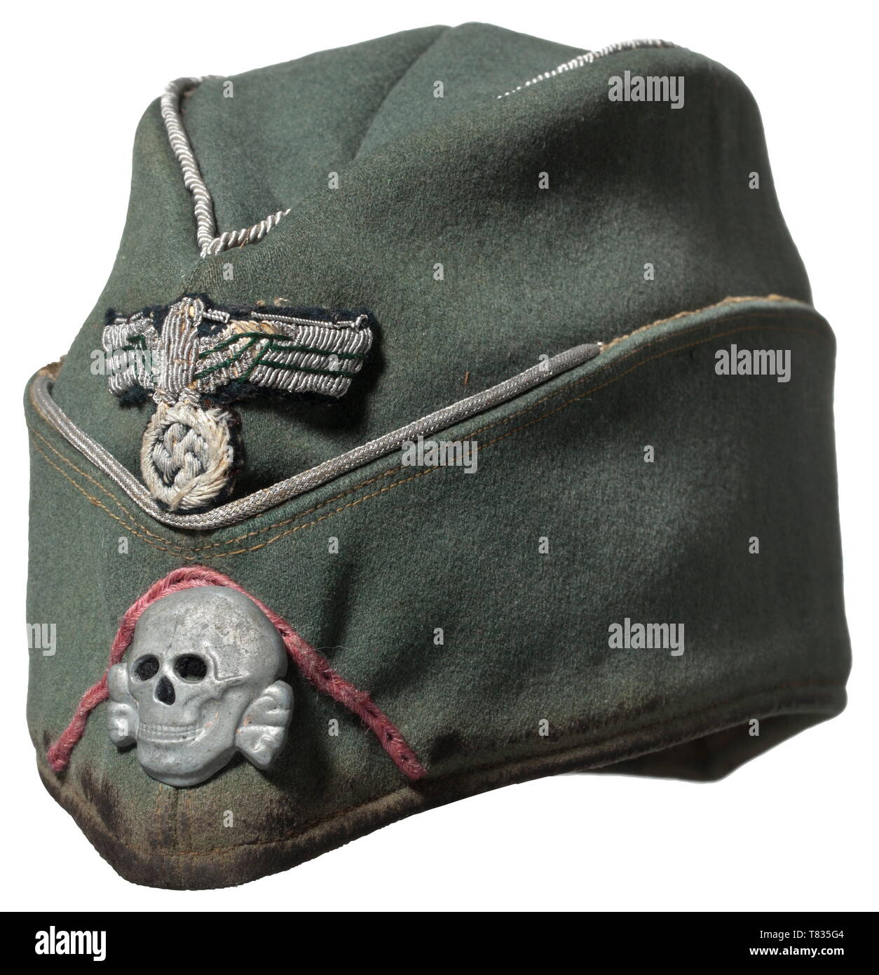 A field- or garrison cap for SS leaders of motorised Panzer units in green gabardine with silver piping. In contrast to regulations for wear: hand-embroidered army national eagle on a dark green cloth underlay. Applied death's head in fine zinc, the reverse with two cotter pins and a black cloth underlay, pink soutache chevron for members of motorised Panzer units, petrol blue lining with obvious signs of usage, without maker's designations, large size (ca. 57). A clearly used garrison cap of utmost rarity. historic, historical, 20th century, 1930s, 1940s, Waffen-SS, armed , Editorial-Use-Only Stock Photo