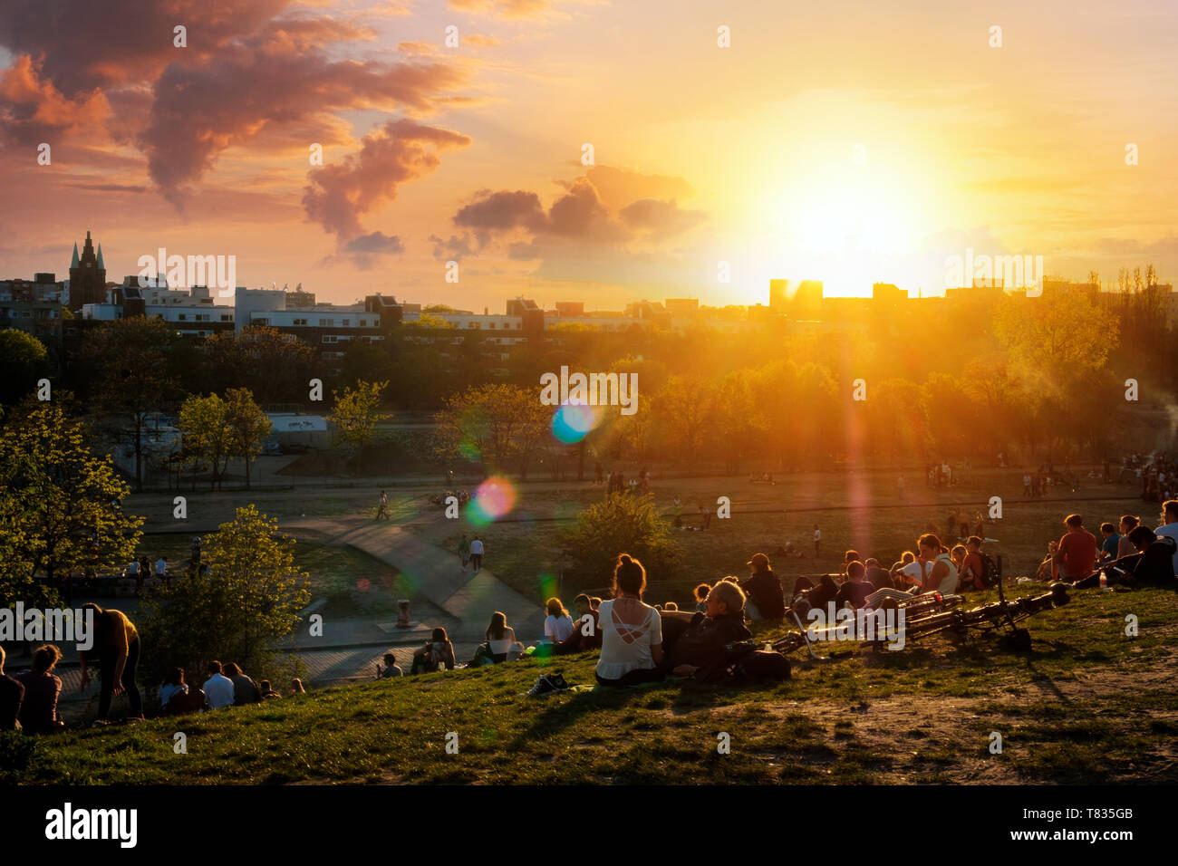 Berlin, Germany - April, 2019: People enjoying view on sunset sky over skyline from public park (Mauerpark) on summer day in Berlin Stock Photo