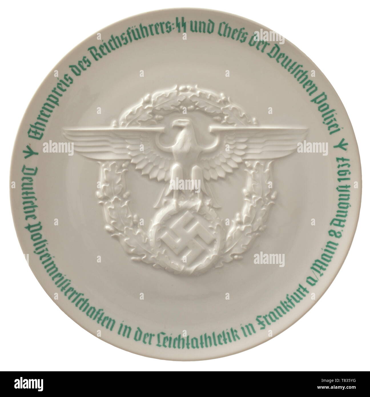 An honour prize plate of the Reichsführer SS White glazed porcelain, the front applied with a relief-moulded police eagle, the edge surrounded by the green underglaze inscription (tr) 'Honour prize of the Reichsführer SS and head of the German police - German police athletics championships in Frankfurt on the Main 8 August 1937'. The bottom with green underglaze mark 'SS Allach'. Diameter circa 24 cm. historic, historical, porcelain, chinaware, 20th century, Editorial-Use-Only Stock Photo