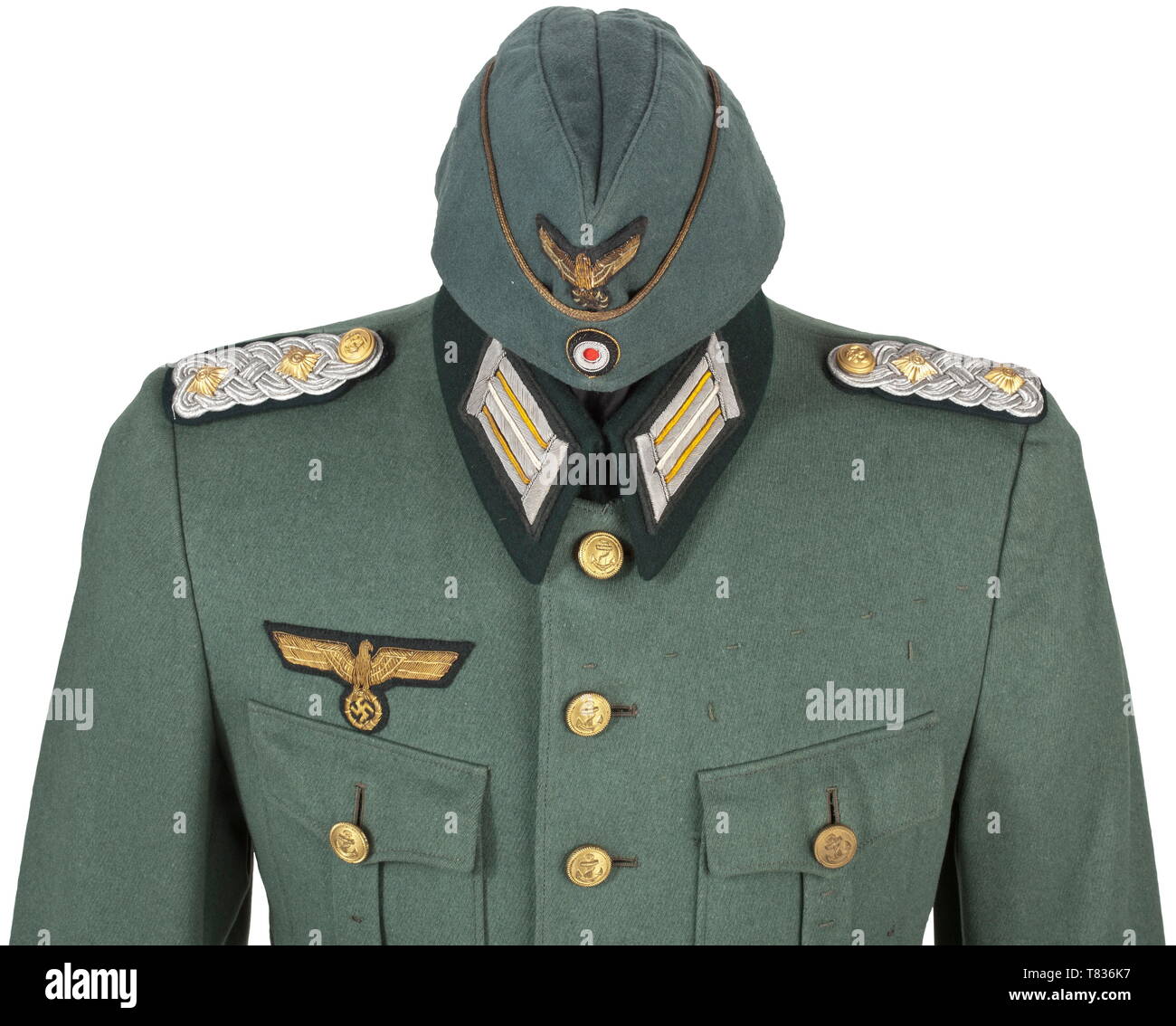 A field cap and a tunic for a Kapitän zur See in the coast artillery Garrison cap of field-grey cotton material with gold piping and hand-embroidered insignia. Grey silk inner lining with obvious signs of usage, no maker, size ca. 56. The jacket of grey-green cotton cloth with hand-embroidered insignia. Slip-on shoulder boards in the rank of Kapitän zur See (naval captain), orders loops on both sides of the chest for the German Cross in Gold and the Iron Cross 1st Class with Repetition Clasp, field orders clasp and other decorations. Dark grey inner lining without maker des, Editorial-Use-Only Stock Photo