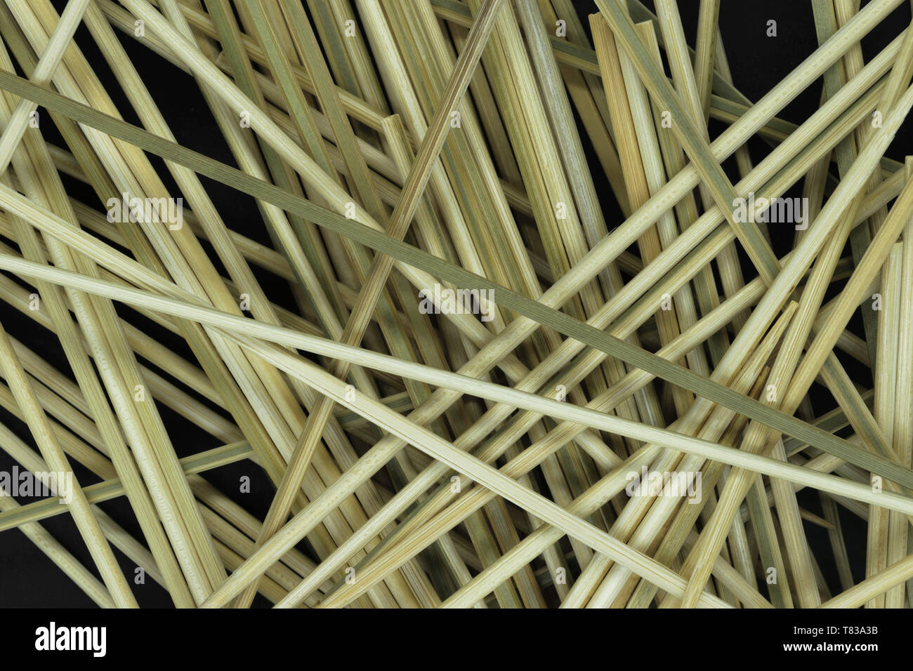 Messy looking background of natural bamboo skewers which are used for cooking on black background Stock Photo