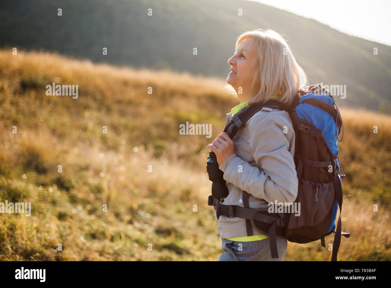 Senior woman is hiking in mountain. Active retirement. Stock Photo