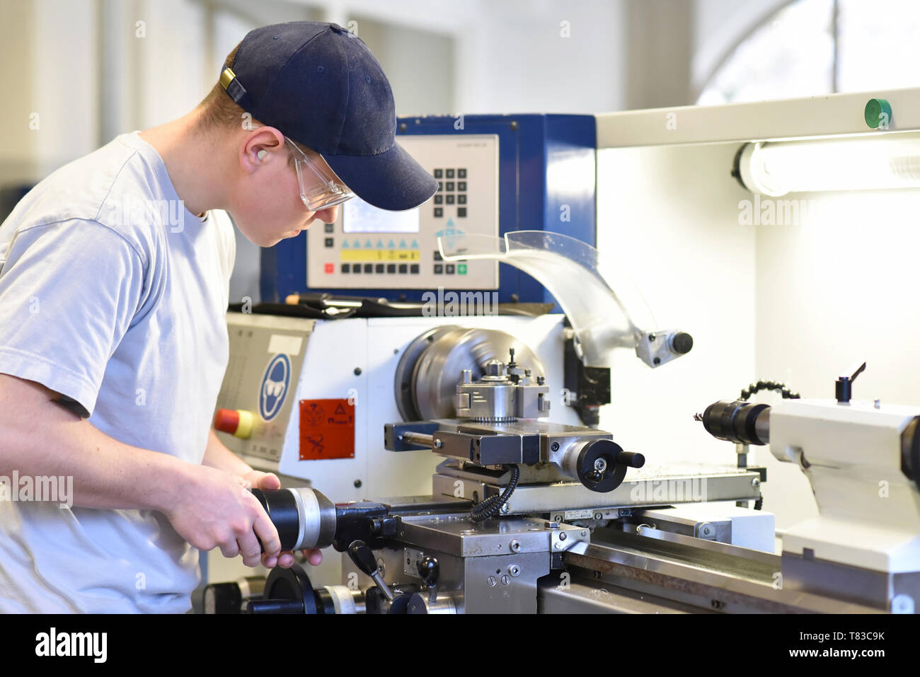 young apprentice in vocational training working on a turning machine in the industry Stock Photo