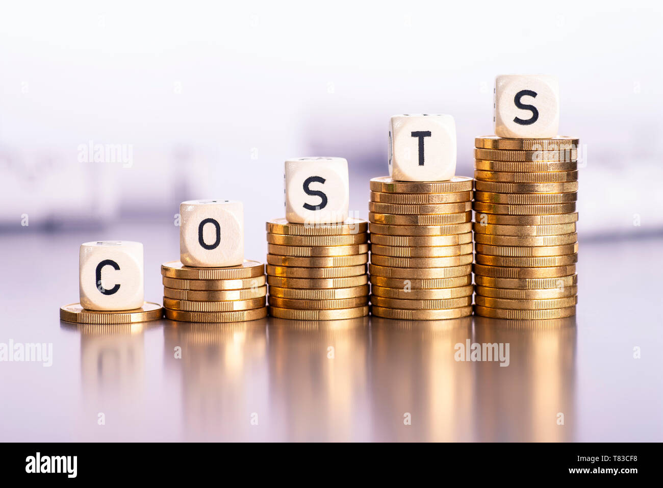 Rising stacks of coins with the word costs Stock Photo