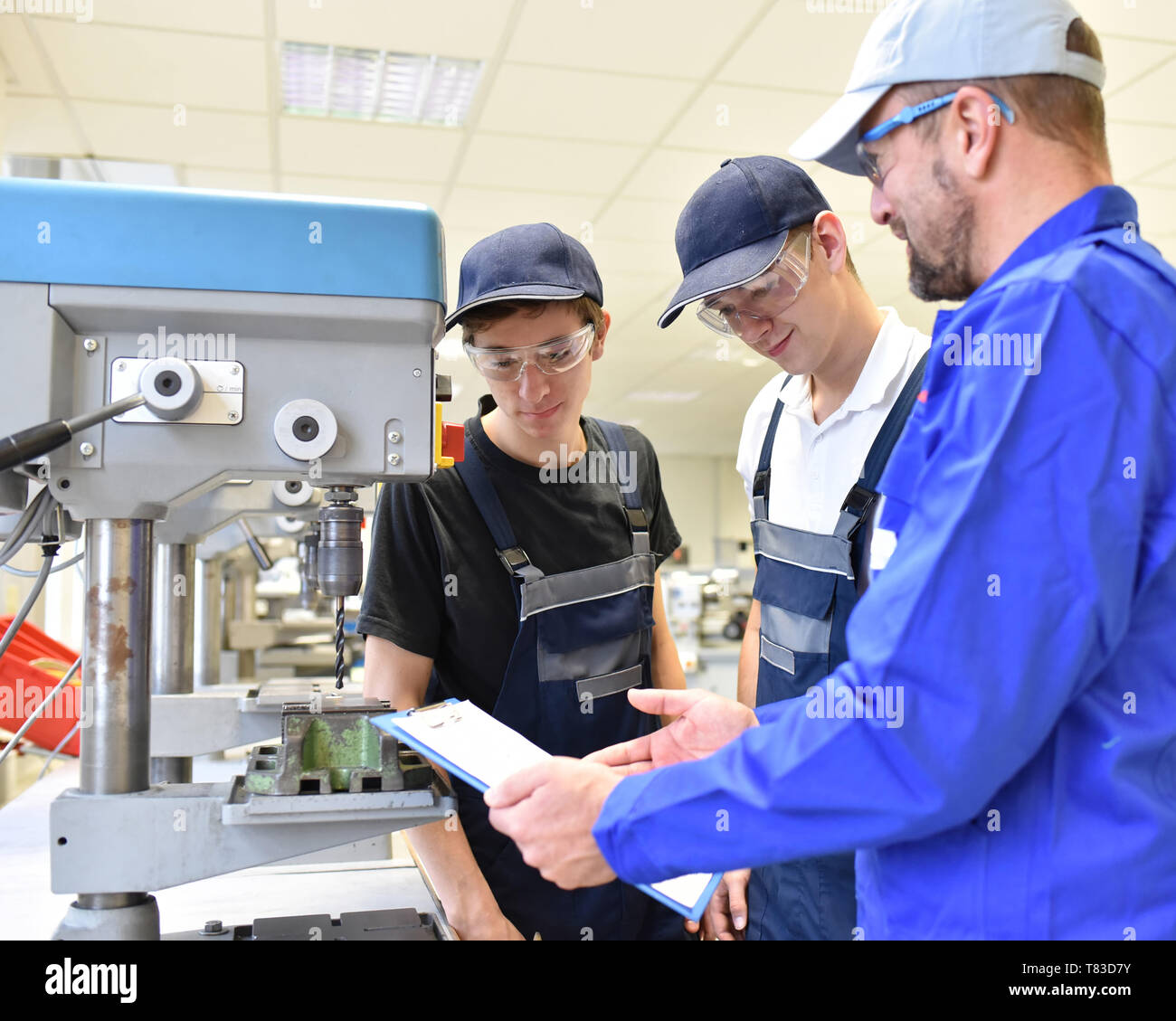 trainer and apprentice in technical vocational training at a drilling machine Stock Photo
