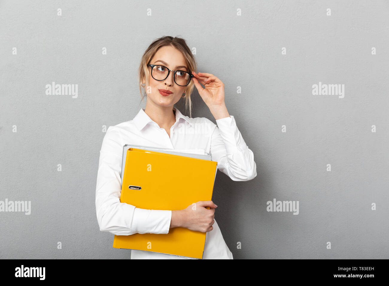 Photo of successful secretary wearing glasses holding paper folders in ...