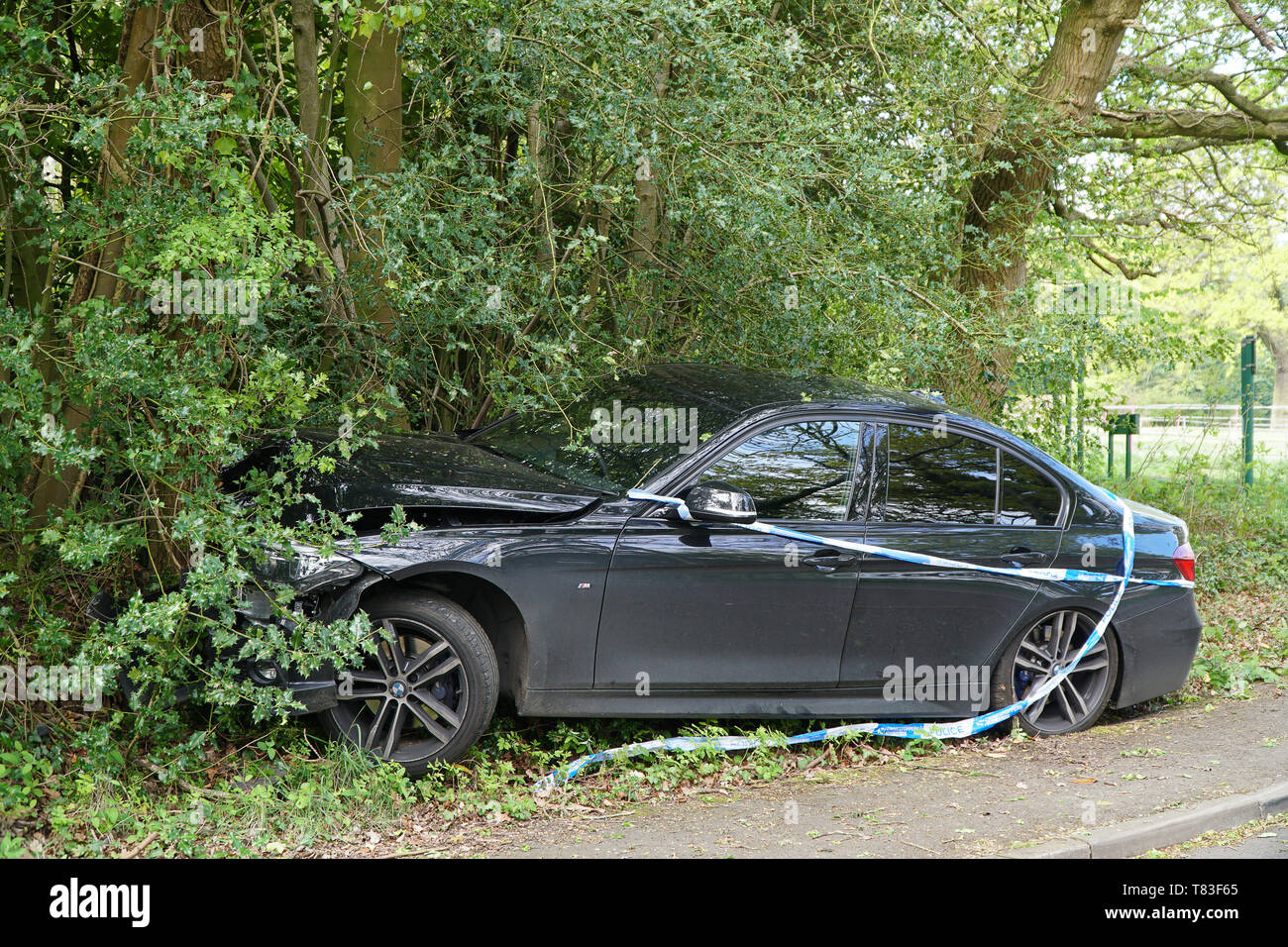 A single vehicle collision involving a car that has left the road at speed and mounted the pavement Stock Photo