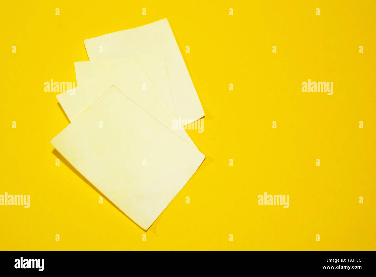 Three blank yellow sticky notes isolated on an orange background Stock Photo