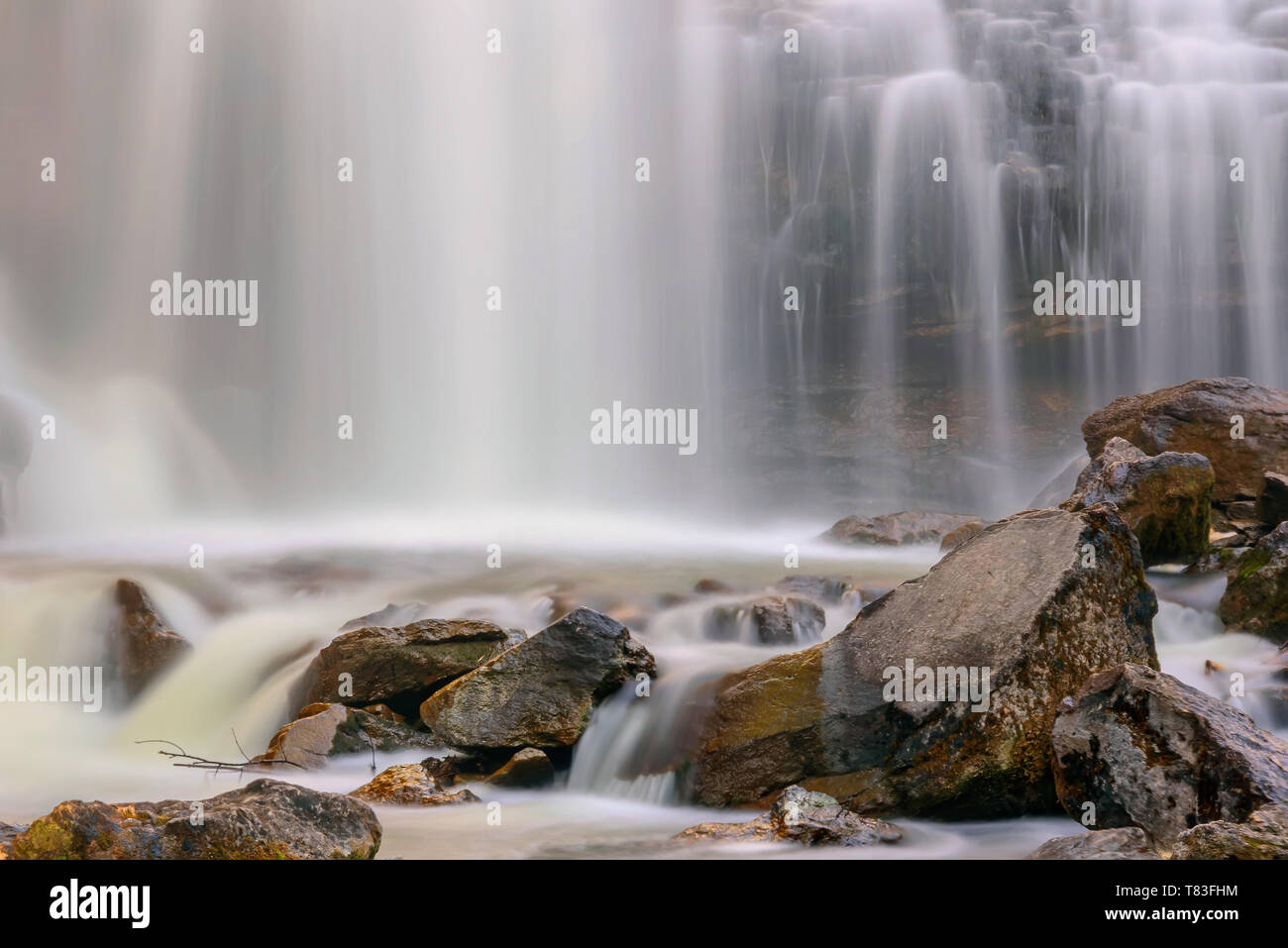 Beautiful waterfall with smooth silky water among rocks and stones, shot on long exposure Stock Photo