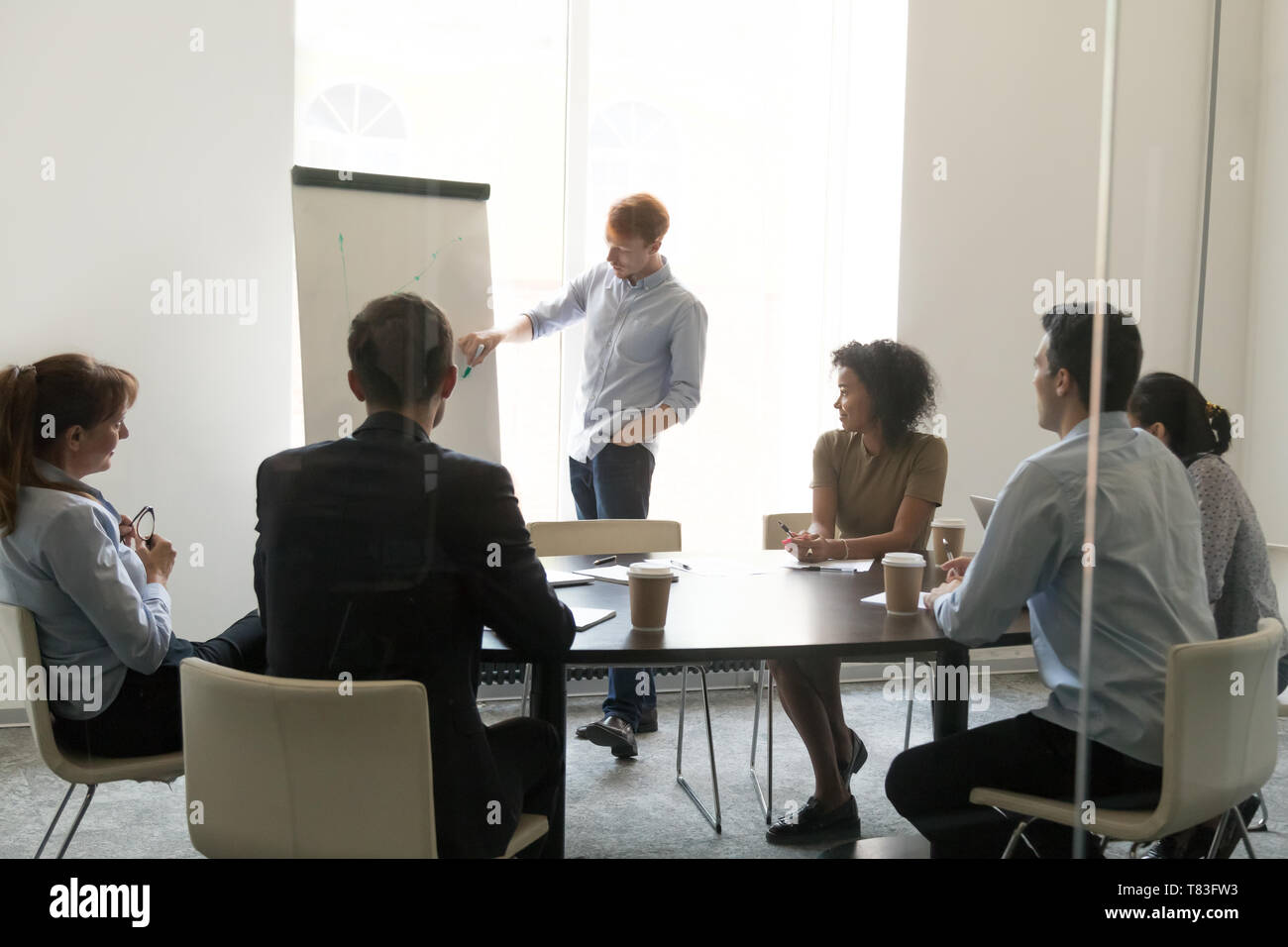Male coach make flipchart presentation for diverse employees Stock Photo
