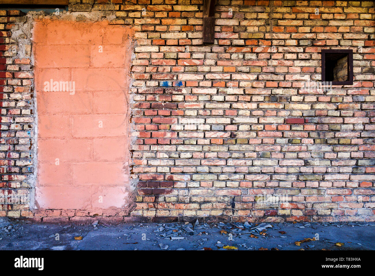 Yellow brick wall, part painted in pink, background with a ground