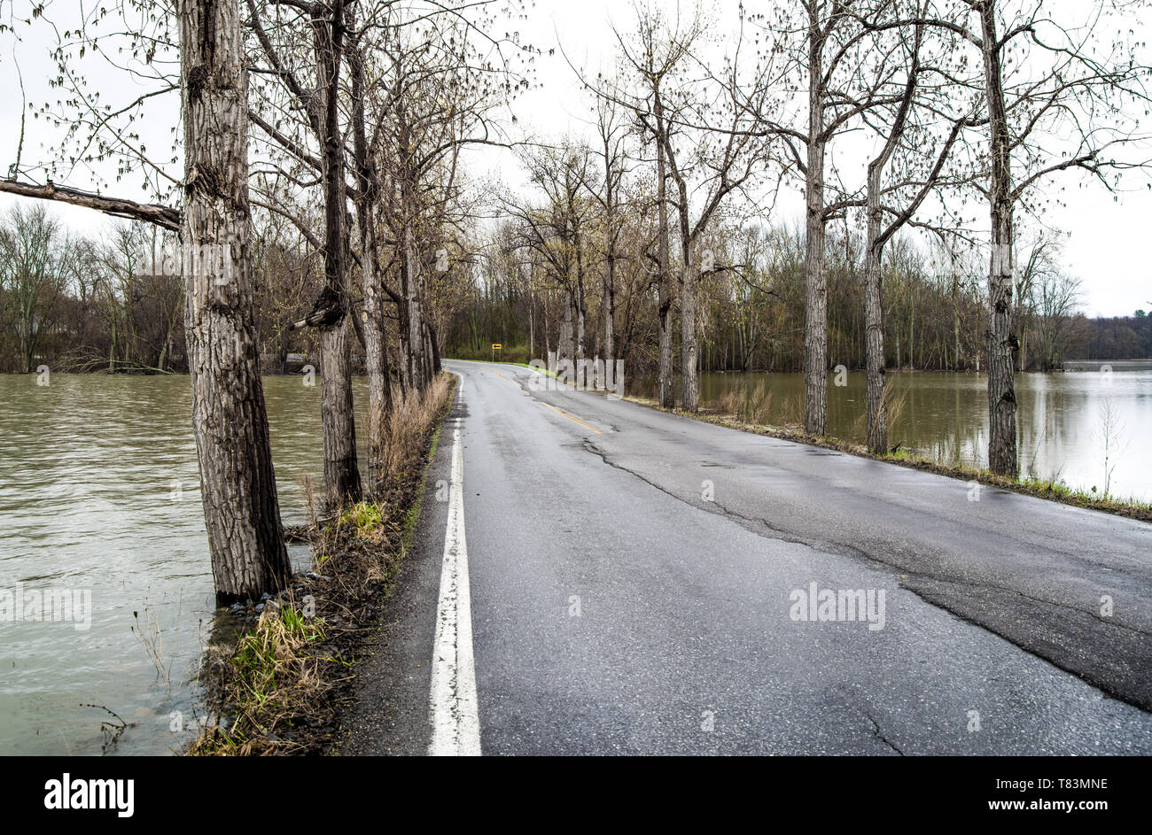 High Water: The level of water nearly reaches the edge of a narrow causeway across the southern end of Lake Champlain on a rainy spring day in Vermont. Stock Photo