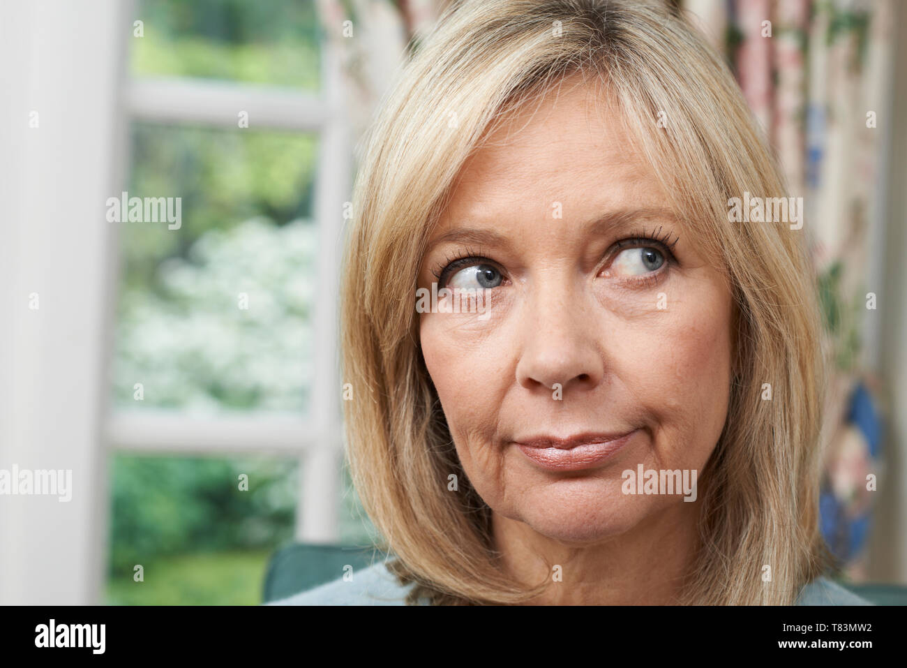 Head And Shoulders Shot Of Thoughtful Mature Woman At Home Stock Photo