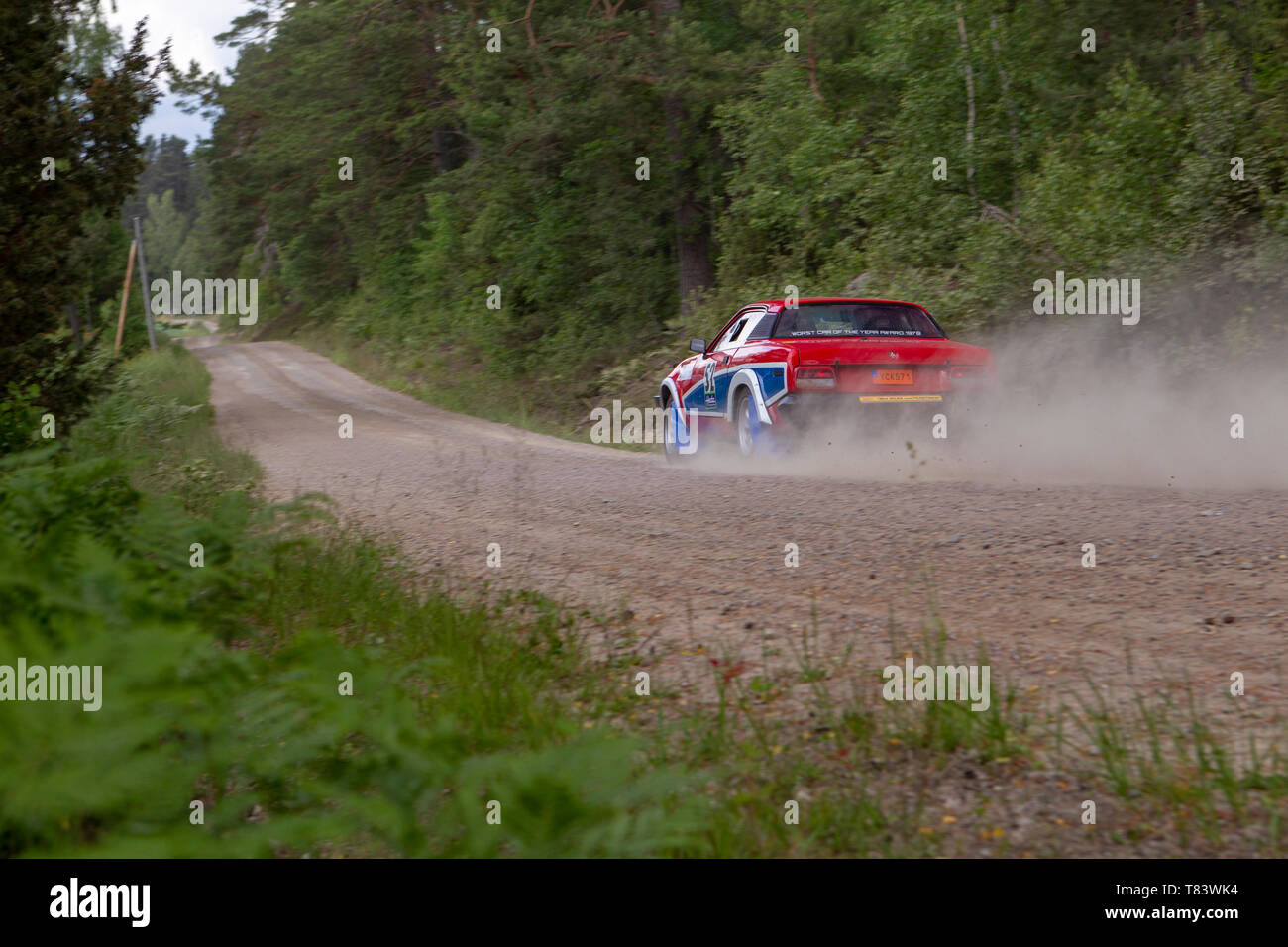 Fast rally car on a dusty dirt road in sweden Stock Photo
