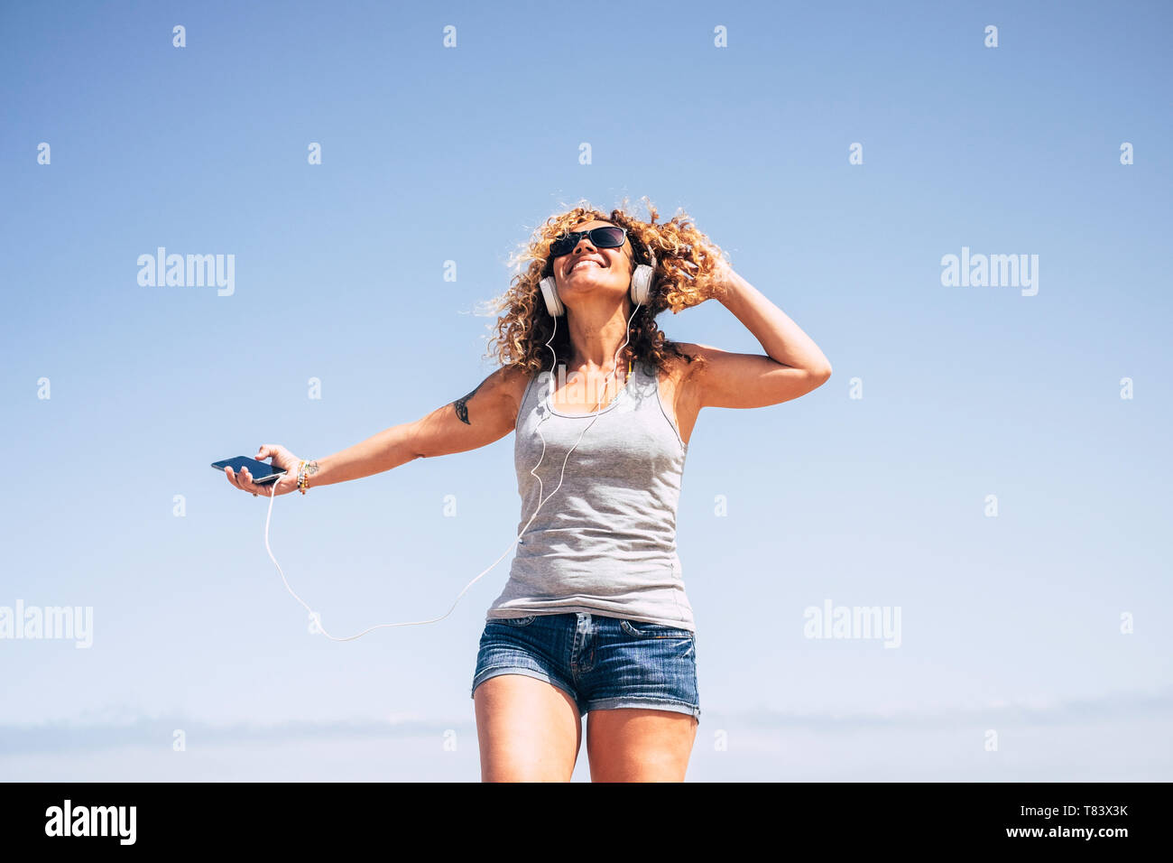 Happy woman enjoying life. One people middle aged with curly hair outdoor on the beach. Freedom concept and joy Stock Photo