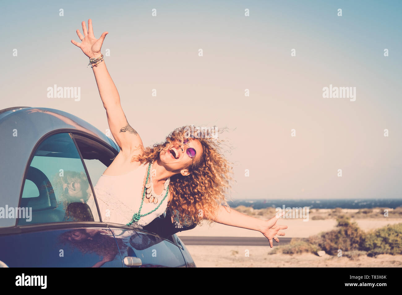 Happy woman enjoying life. One people middle aged with curly hair outdoor of the window car. Freedom concept and joy. Horizon over water Stock Photo