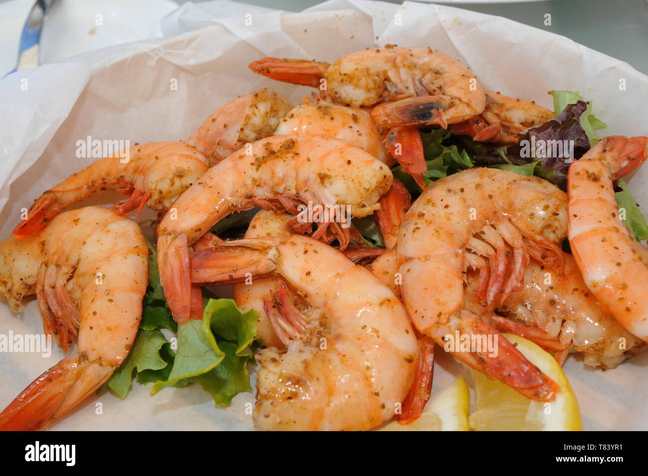 Close up of plate with delicious, mouthwatering, cooked, whole, fresh Key West Pink Shrimp with lemon slices, Key West, Florida, USA Stock Photo