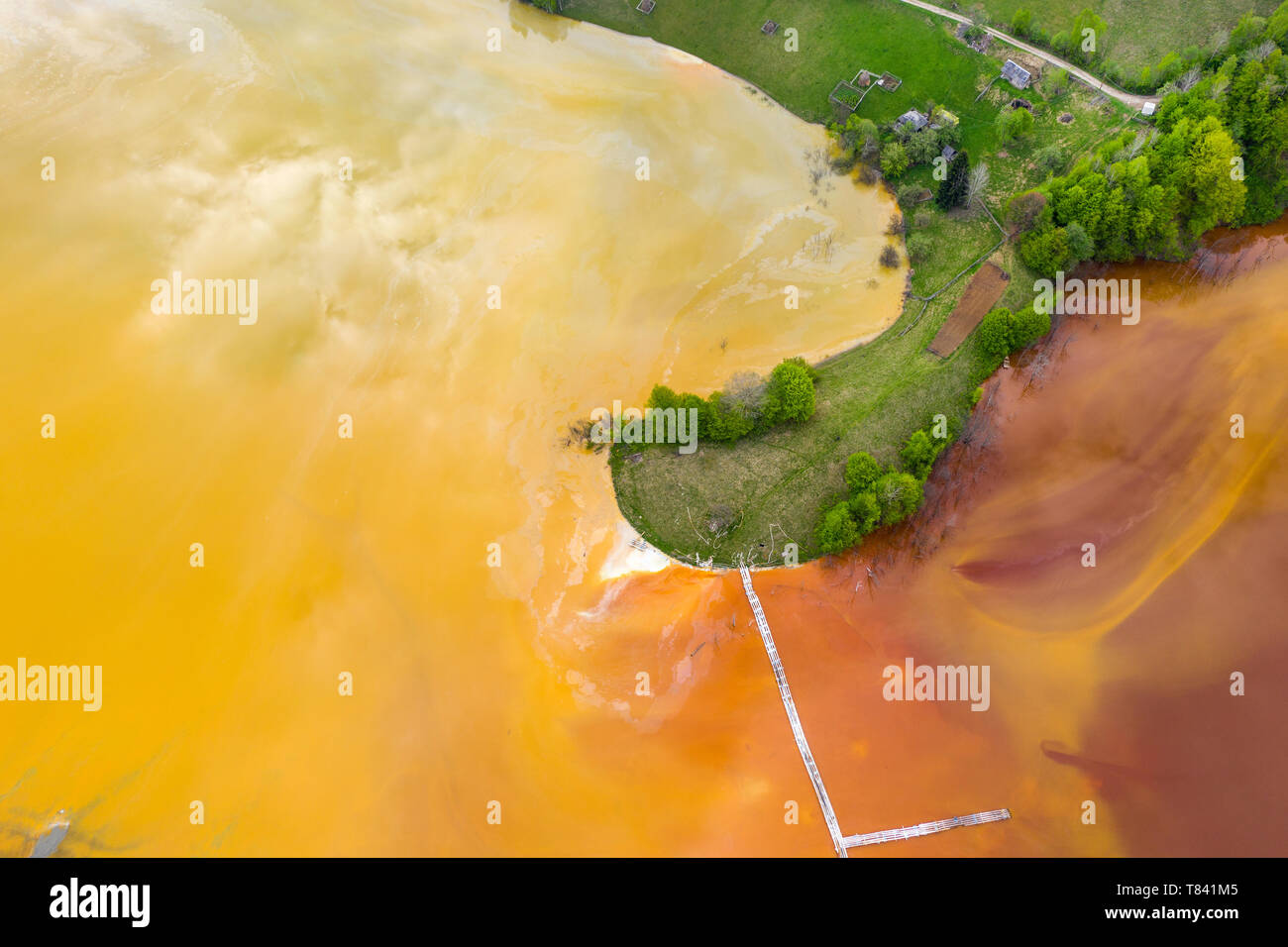 Aerial view of chemical mining waste residuals flooding into a settling