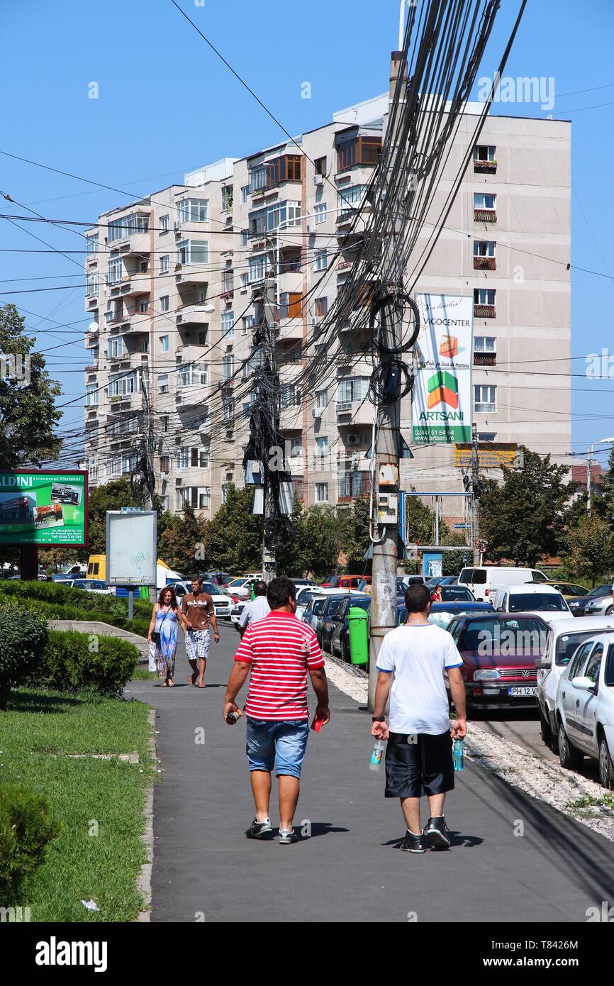 PLOIESTI, ROMANIA - AUGUST 20, 2012: People walk under tangled cables in Ploiesti, Romania. Ploiesti is the 9th largest city in Romania and exists sin Stock Photo