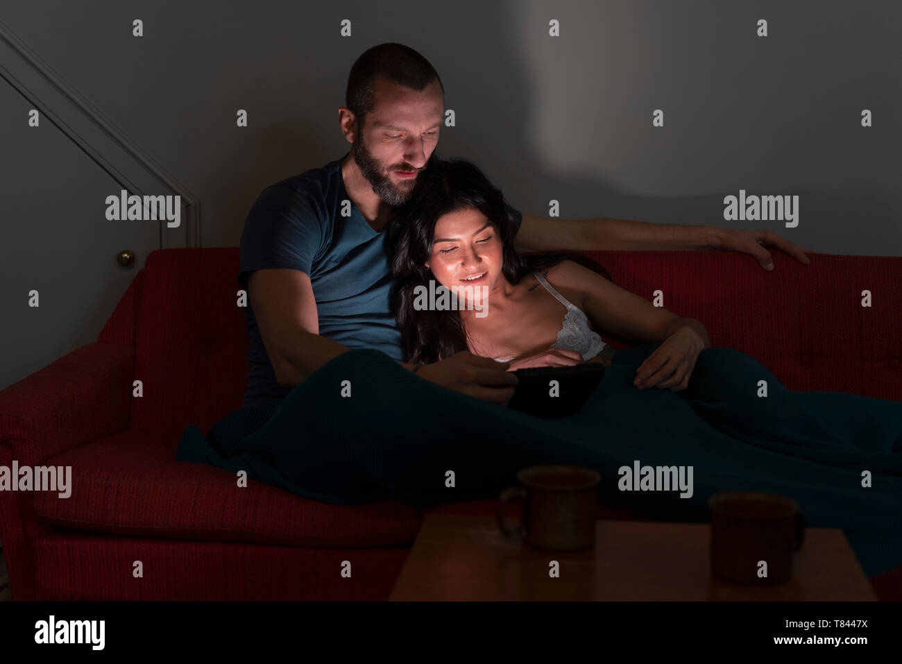 Hipster couple using digital tablet on sofa Stock Photo