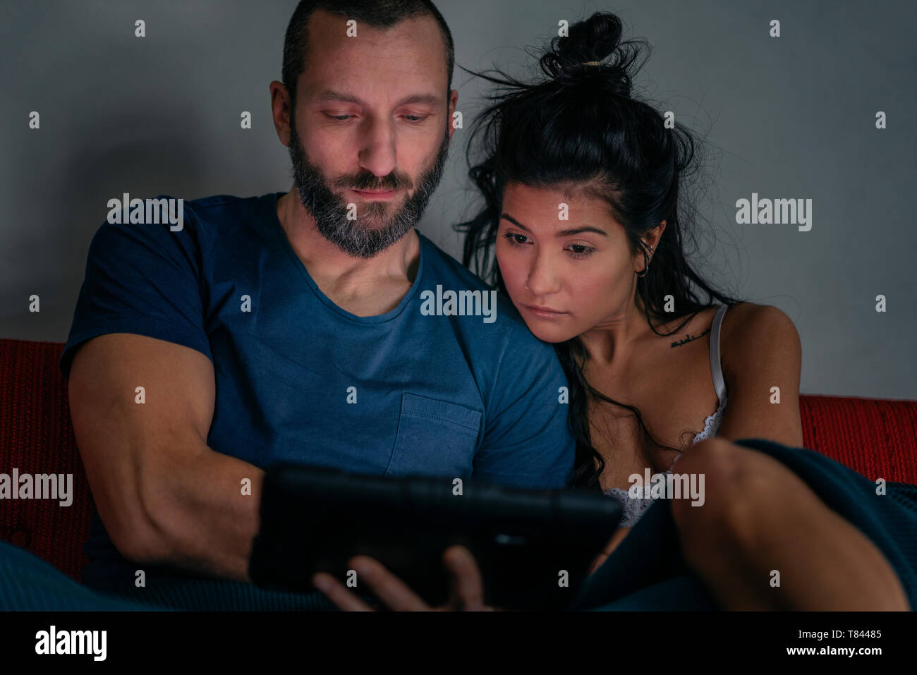 Hipster couple using digital tablet on sofa Stock Photo