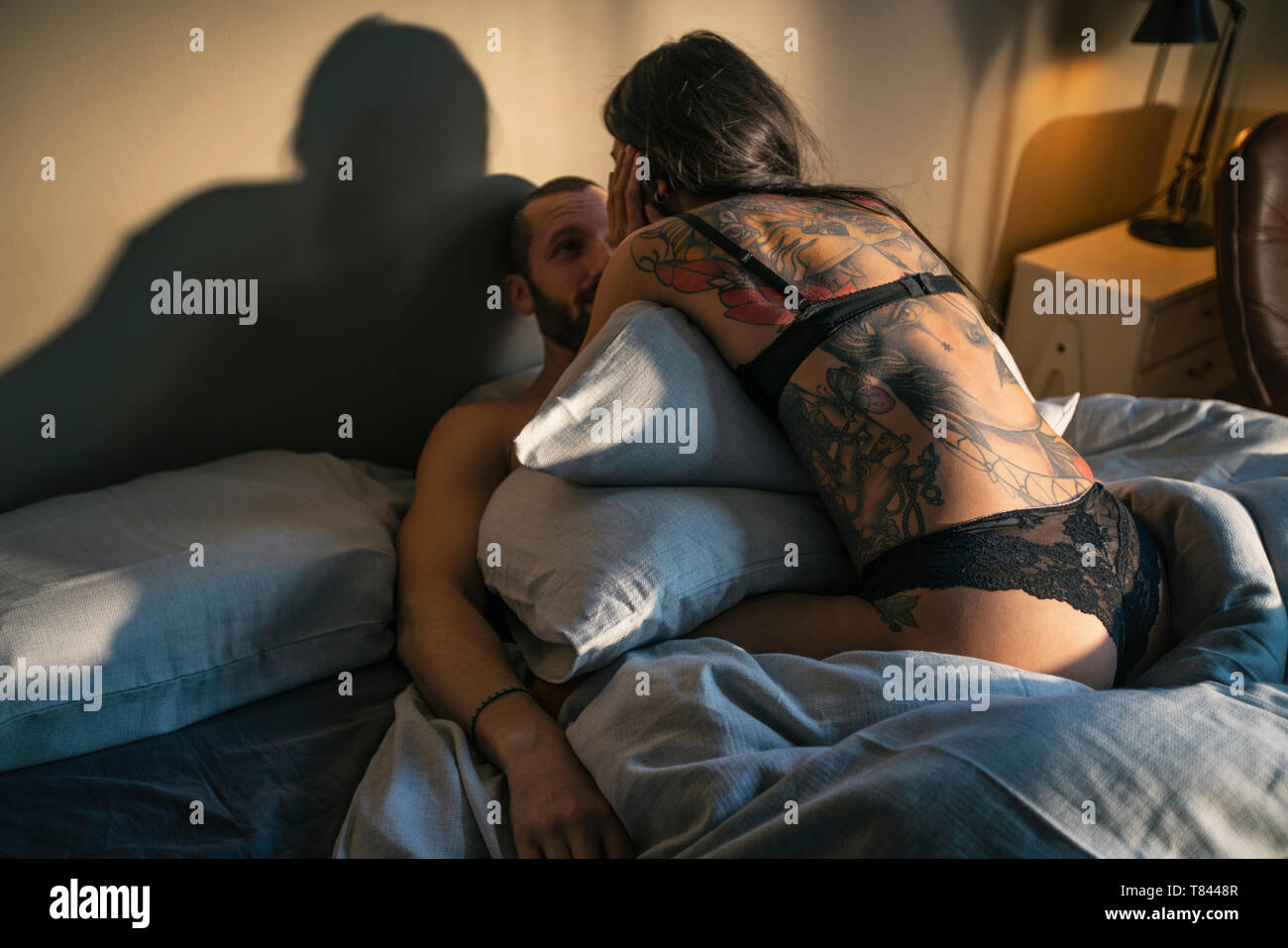 Semi-naked hipster couple in bed Stock Photo
