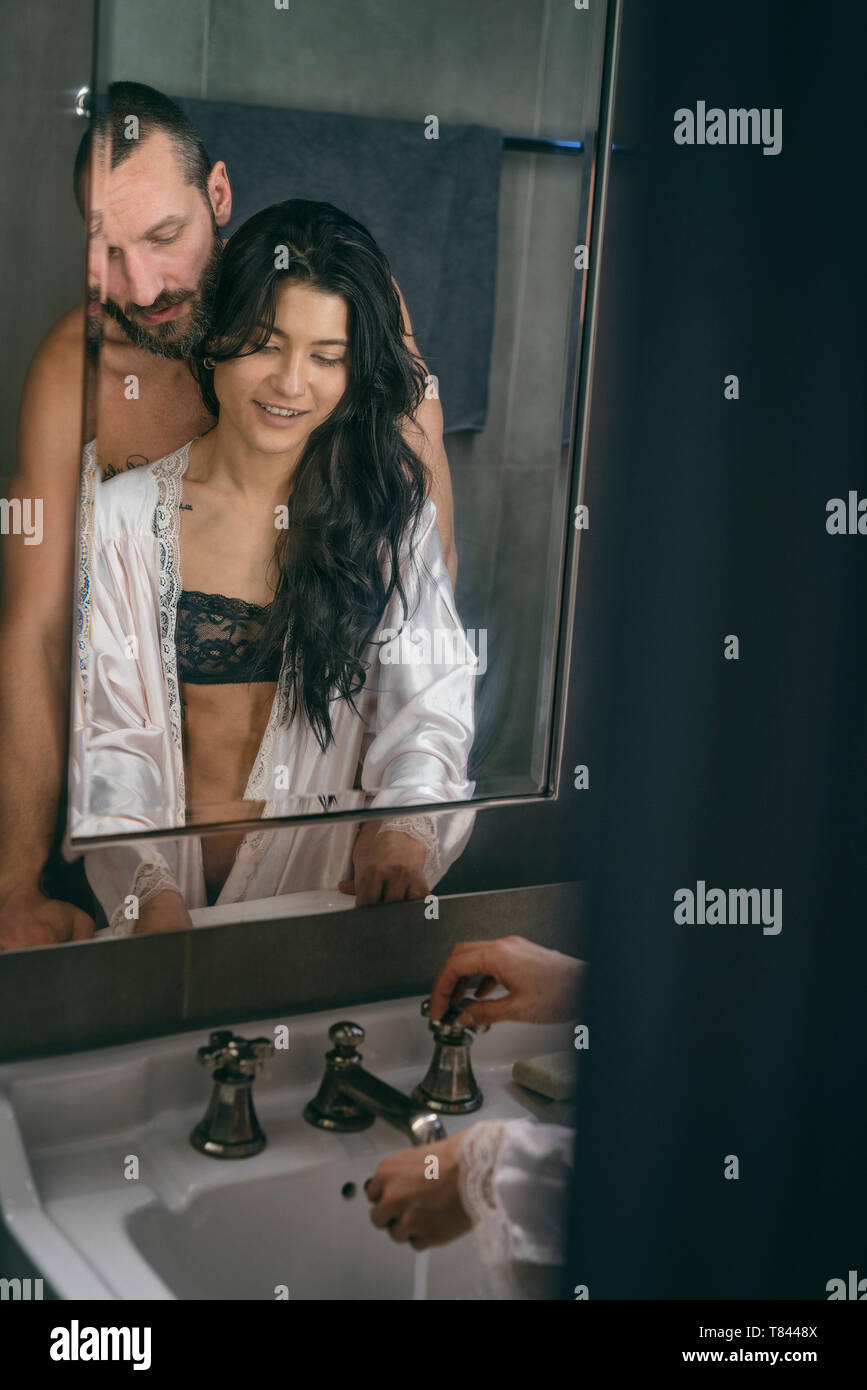 Semi-naked hipster couple washing hands in bathroom Stock Photo