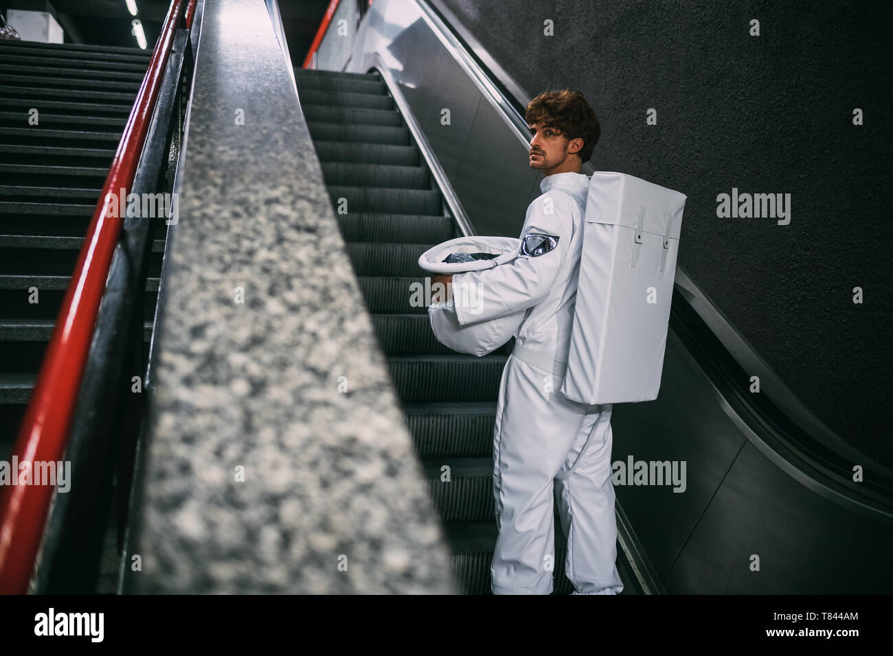 Astronaut going up escalator Stock Photo