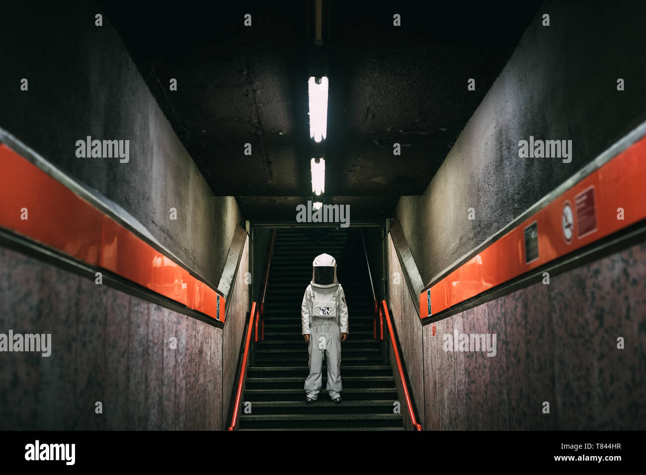 Astronaut on stairway in train platform Stock Photo