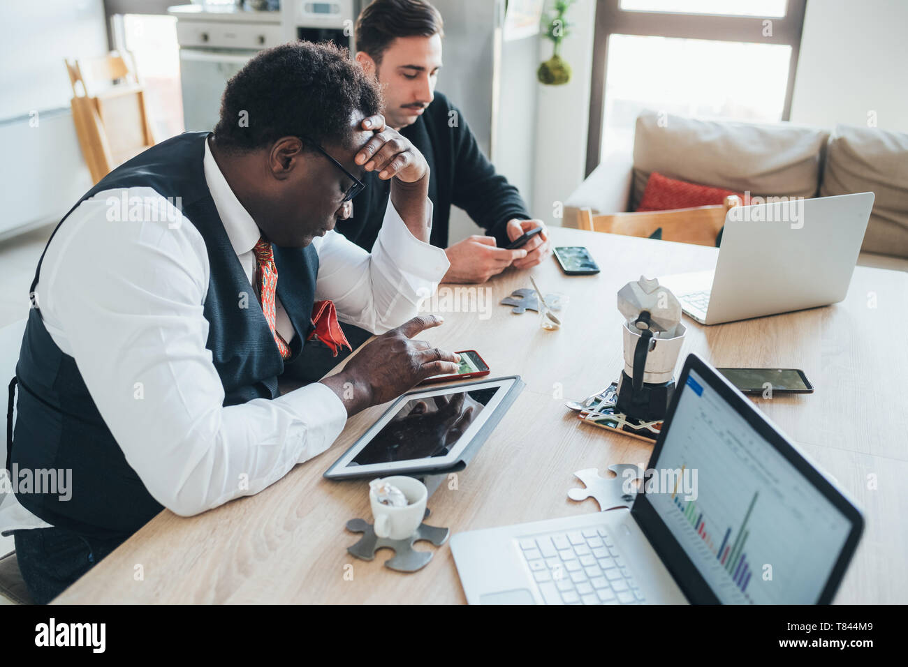 Businessmen using smartphone in loft office Stock Photo