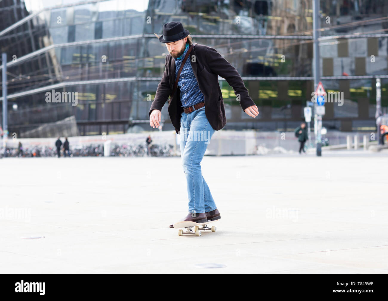 Man skateboarding in city square, Freiburg, Baden-Wurttemberg, Germany Stock Photo