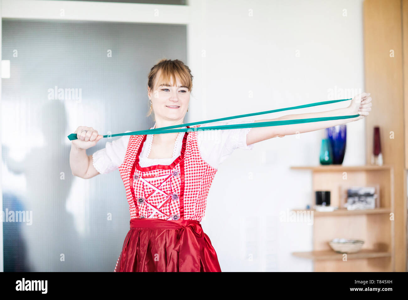Woman stretching resistance band at home Stock Photo
