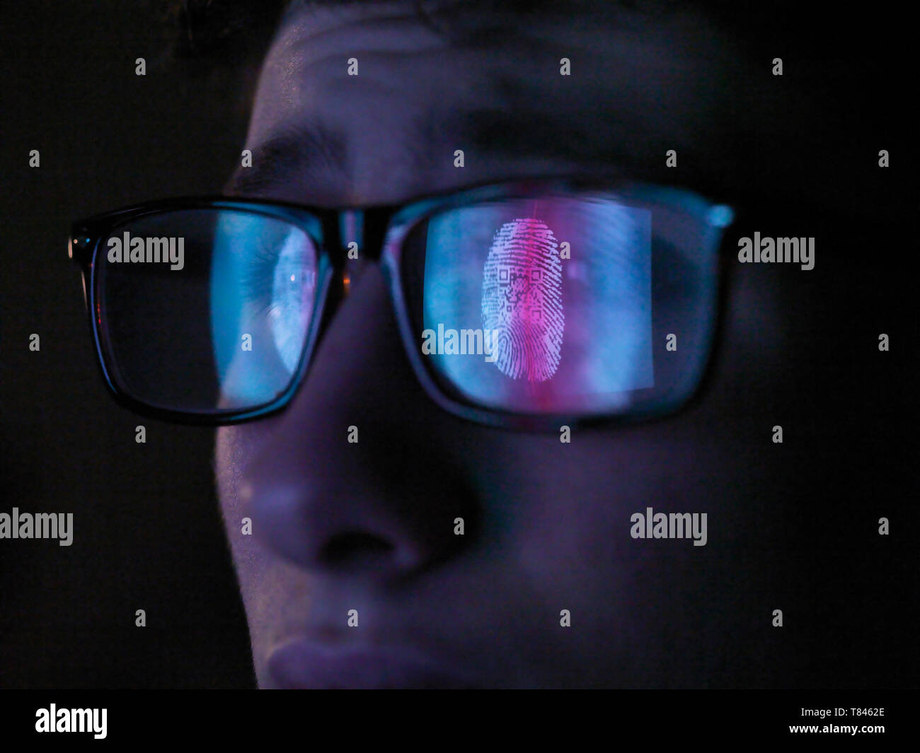 Cyber Security, reflection in spectacles  of access information being scanned on computer screen, close up of face Stock Photo