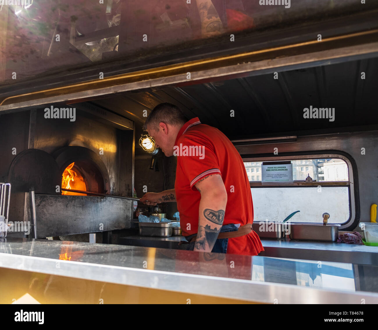 Newcastle, United Kingdom - February 23, 2019: A man bakes pizzas in a rennovated classic van used as a portable canteen serving pizza at Gateshead, N Stock Photo
