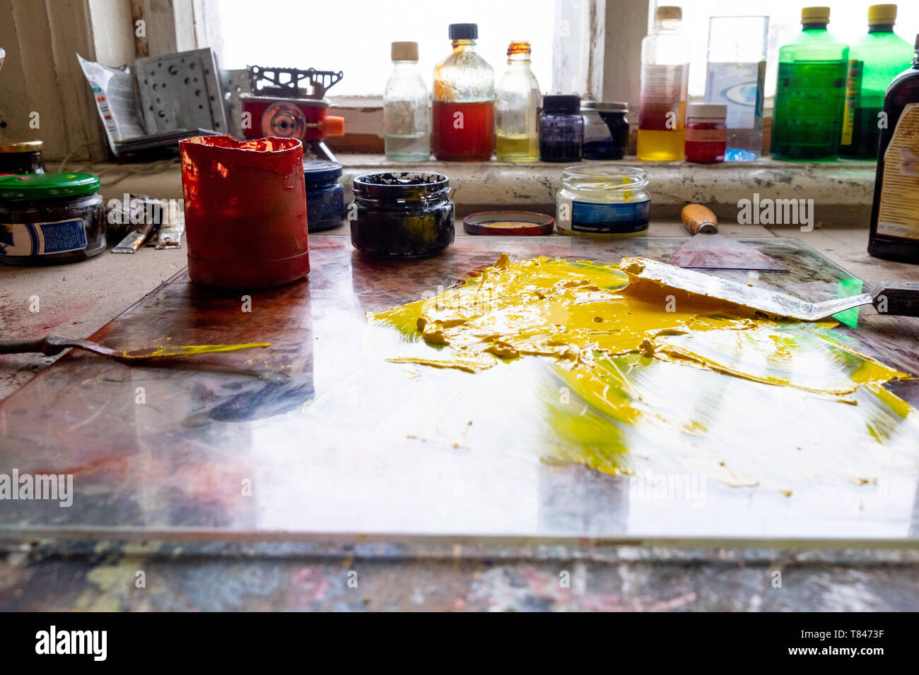 Spilt yellow paint on table Stock Photo