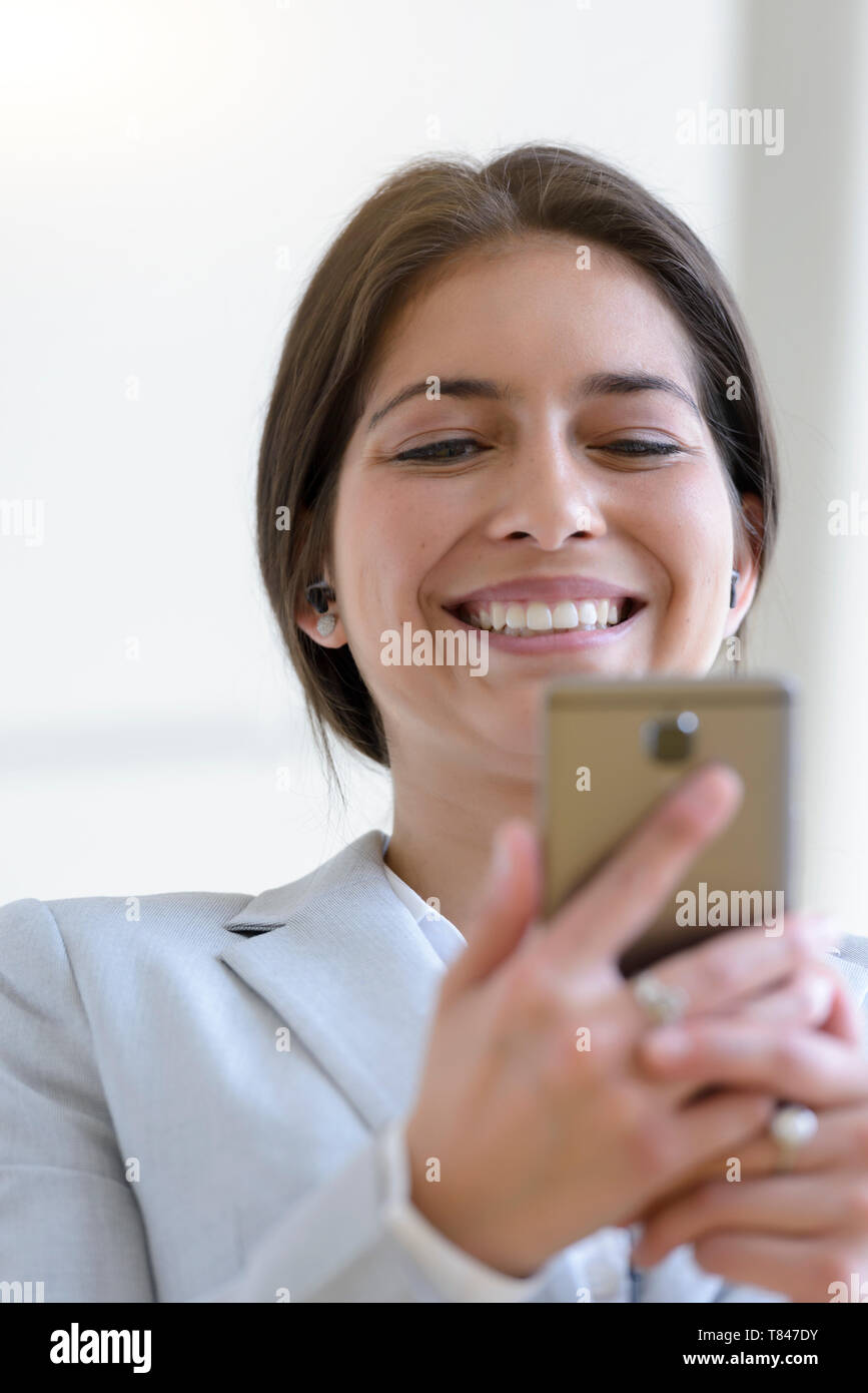 Businesswoman reading good news on smartphone Stock Photo