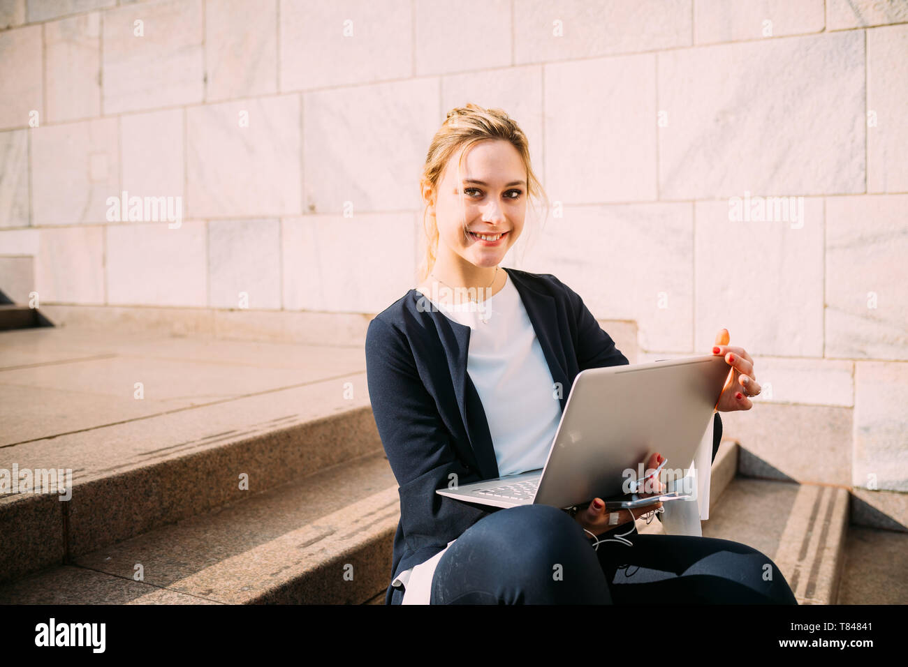 Young woman sitting on city hi-res stock photography and images - Alamy