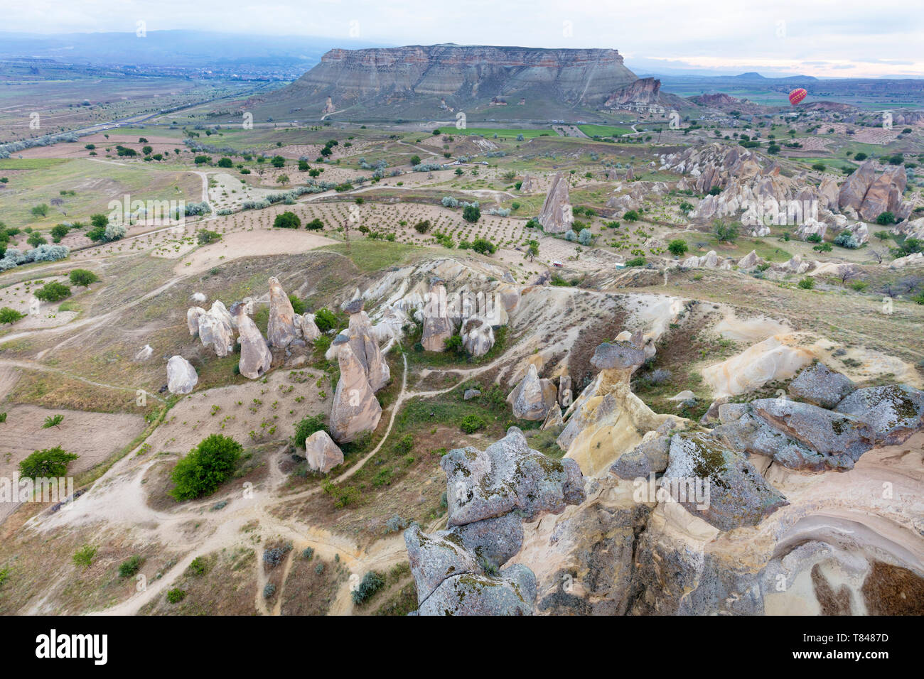 The mountains of Cappadocia impress with their nakedness and openness. Balloons rise above them. Stock Photo