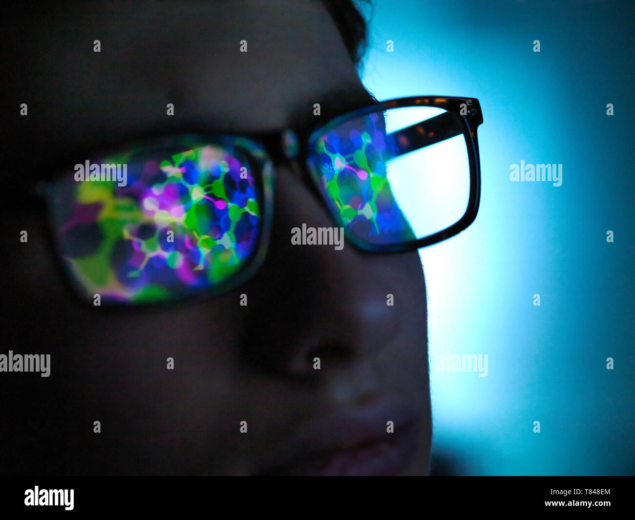 Biotechnology research, computer screen reflection in spectacles of new molecular formula in laboratory, close up of face Stock Photo