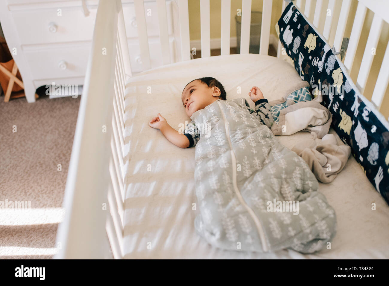 Baby boy lying awake in crib, high angle view Stock Photo