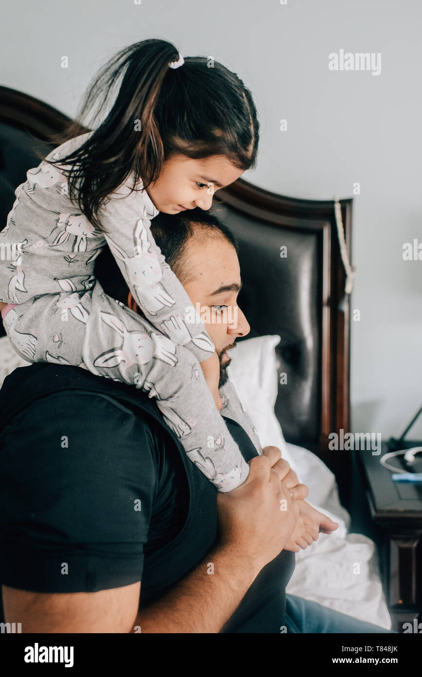 Girl getting shoulder carry from father in bedroom Stock Photo Alamy