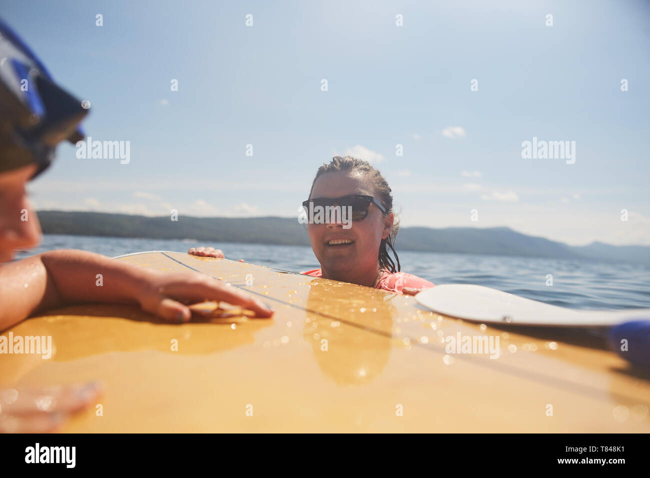 Couple paddle boarding in lake Stock Photo