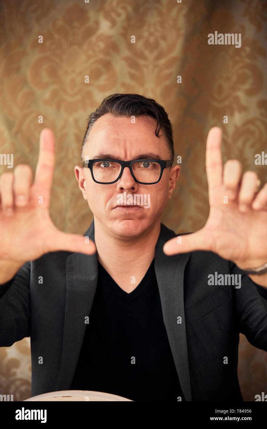 Comedian with camera hand gesture Stock Photo