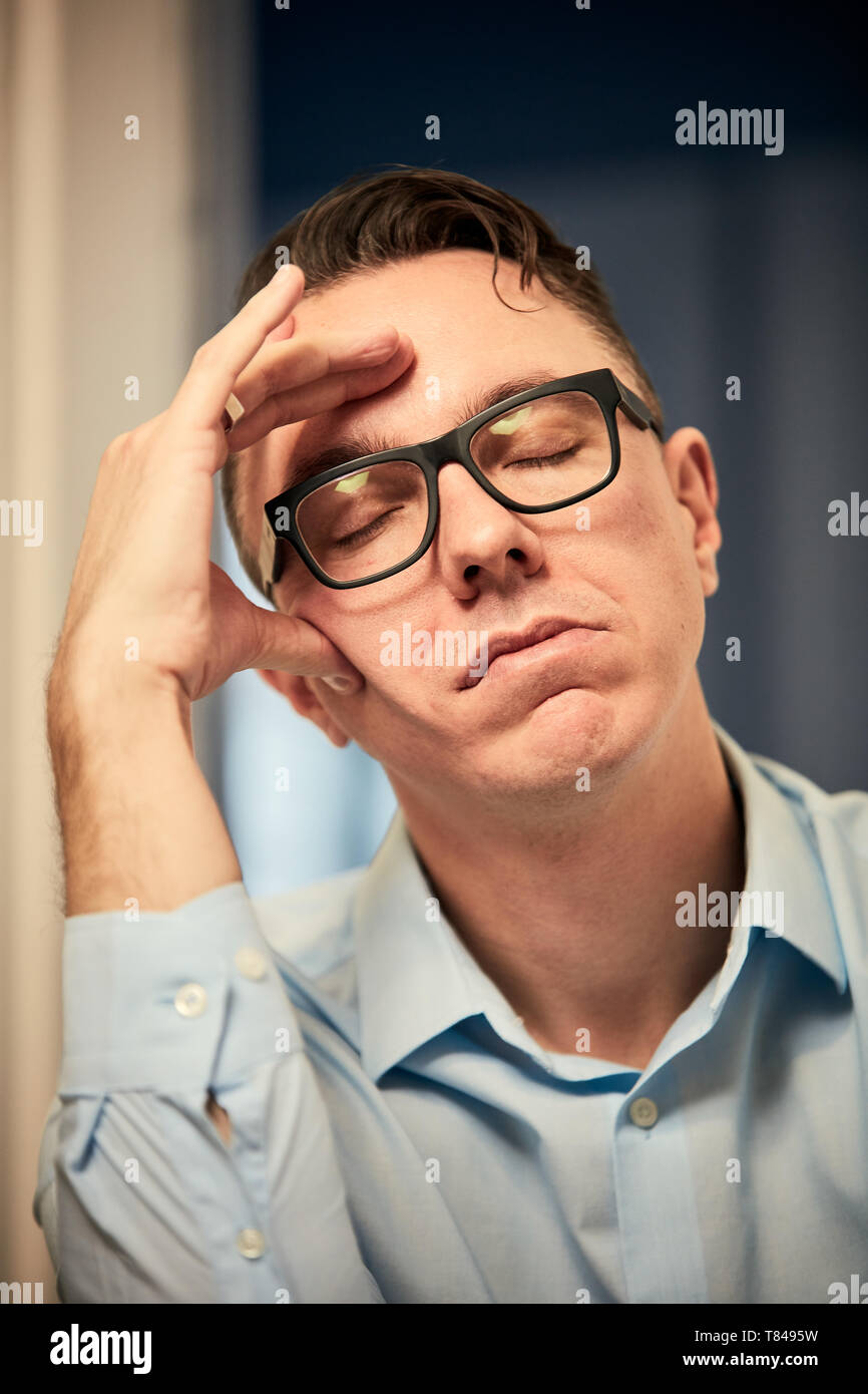 Man resting on elbow with eyes closed Stock Photo