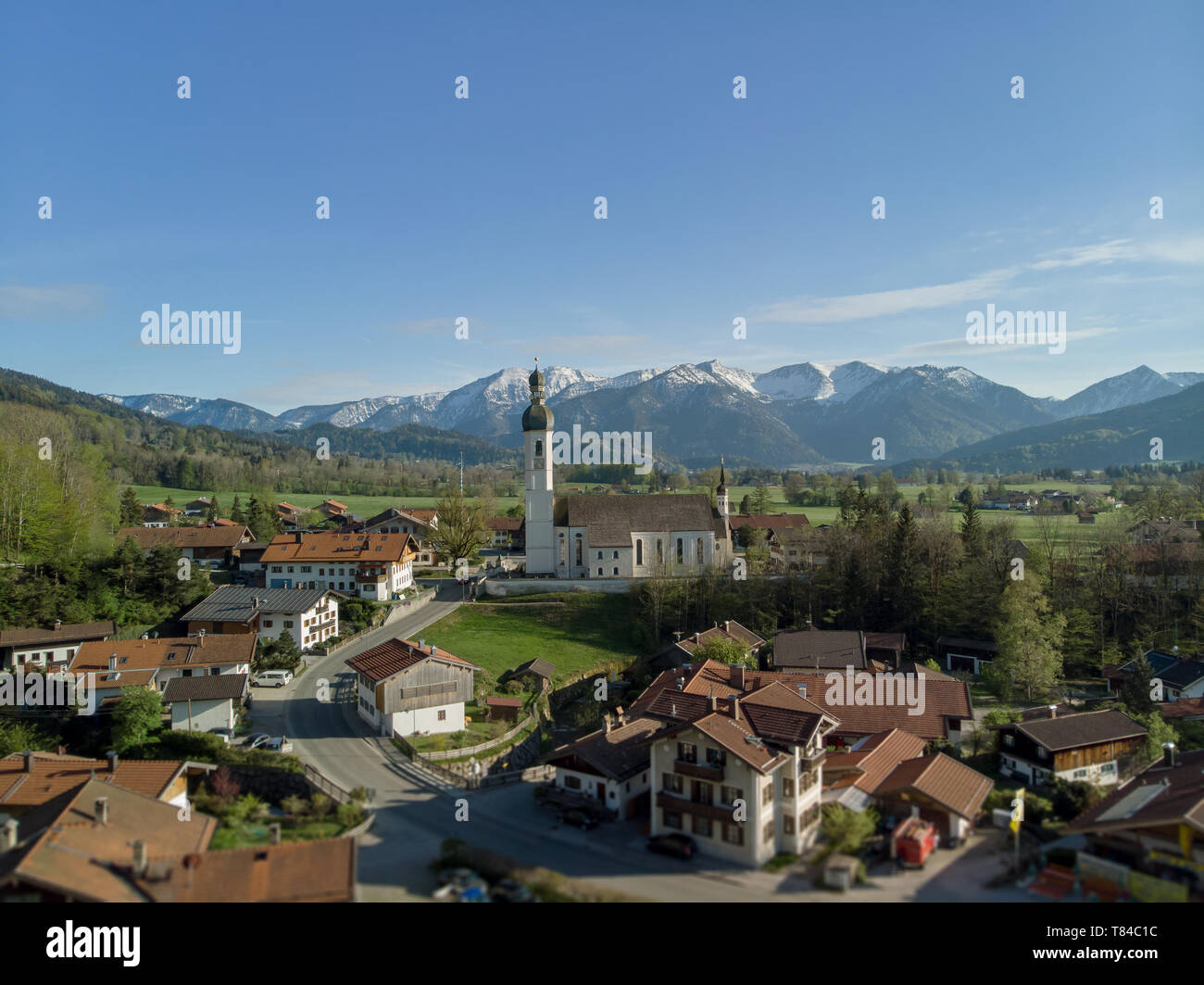 Authentic Bavarian village in beatiful landscape with clear alps in the background and blue sky Stock Photo