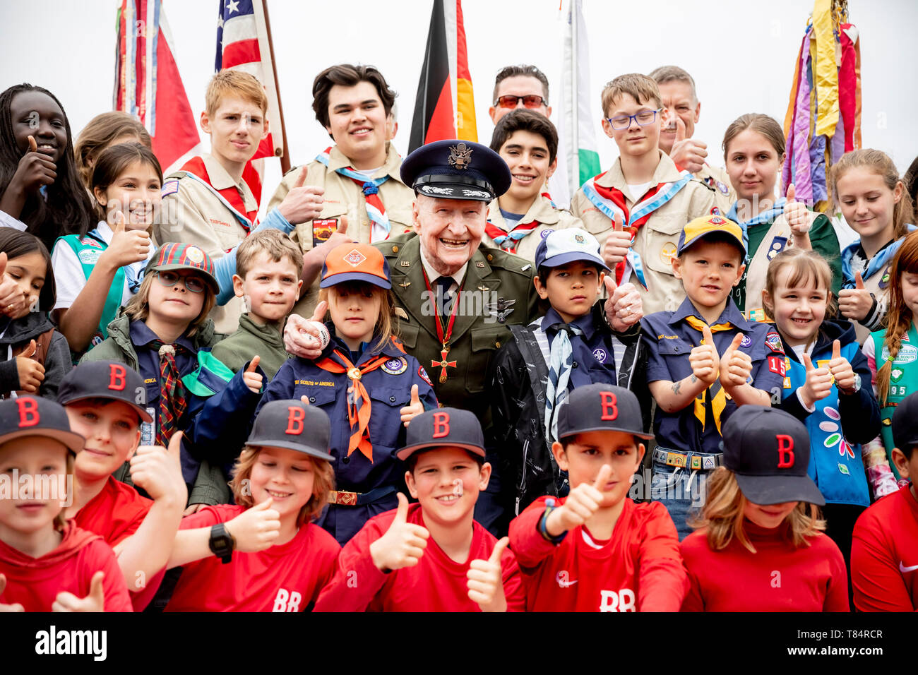 Berlin, Germany. 11th May, 2019. Gail Halvorsen, former airlift pilot of the 'Raisin Bomber', is standing on the baseball and softball court on the Tempelhof field of the Berlin Braves sports club amidst the 'Boy and Girl Scouts of America' team and sports club members. The sports club names its new baseball and softball court after Halvorsen. Credit: Christoph Soeder/dpa/Alamy Live News Stock Photo