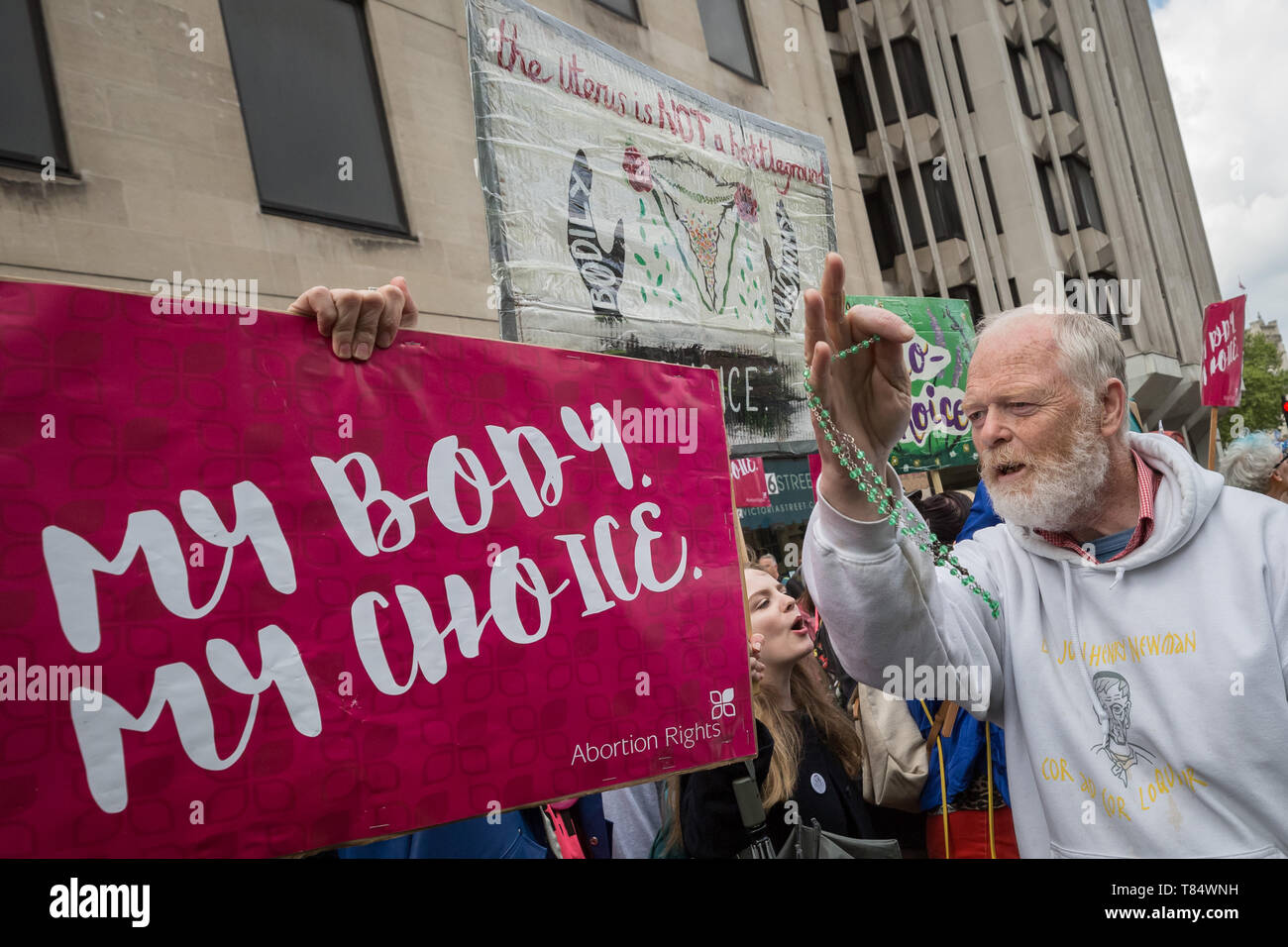 An anti-abortion Christian waves his holy rosaries at women’s rights pro-choice supporters as the groups clash during March for Life UK protest. Stock Photo