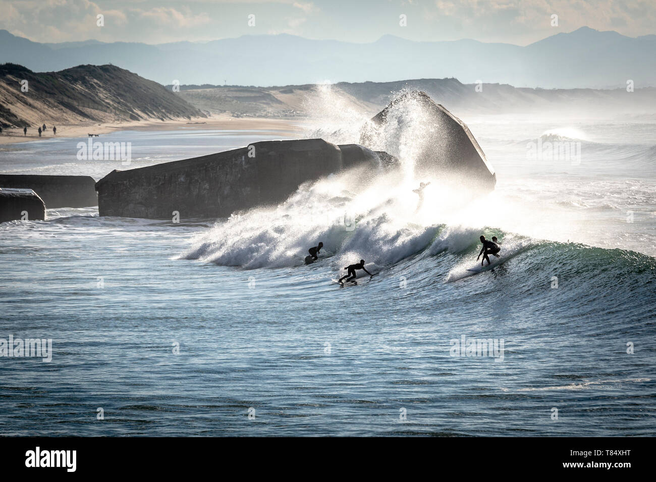 Capbreton (south-western France): surfers on waves, beach “plage de la Savane”, with blockhouses in the background Stock Photo